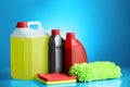 Bottles, stack of cloths and car wash mitt on light blue background Royalty Free Stock Photo