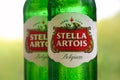 Bottles of Stella Artois beer on blurred green trees background Royalty Free Stock Photo