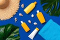 Bottles with sunblock cosmetics and seashells on dark blue background Royalty Free Stock Photo