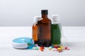 Bottles of syrup, dosing spoon and pills on white table against light grey background. Cold medicine Royalty Free Stock Photo