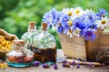 Bottles of tincture and bunch of flowers in wooden box