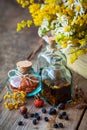 Bottles of tincture and dry herbs, healing herbs in wooden box