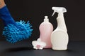 Bottles of washing liquid and hand with a rag on a black background