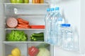 Bottles of water on refrigerator door shelf closeup Royalty Free Stock Photo