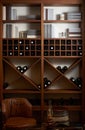 Bottles of white and red wine on a wooden shelf with books in pr Royalty Free Stock Photo