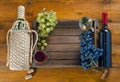 Bottles with wine and grapes in  box on  wooden background Royalty Free Stock Photo