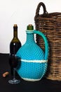 Bottles of wine. Wicker bottle with handle, glass of wine and braided basket