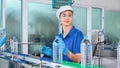 Bottling factory worker inspecting quality of water bottles before shipment. Reverse osmosis system used in plant. water Royalty Free Stock Photo