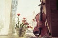 Bottom half of violin with sheet music and flowers the front the front of the fiddle on windows background. Royalty Free Stock Photo