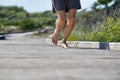 Bottom of man who is running and looks part of the legs wearing gray shorts and barefoot under sunny day.