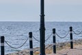 Bottom of an old vintage street lamp. A chain of iron hangs from metal posts against the background of the sea bay Royalty Free Stock Photo