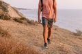 Bottom part of hiker man with backpack walking on the coast with warm sunlight Royalty Free Stock Photo