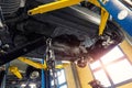 Bottom POV big modern SUV car with removed gearbox raised on lift elevator at workshop service maintenance station Royalty Free Stock Photo