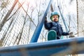 Bottom POV view brave courage little toddler child boy wear safety equipment helmet enjoy passing obstacle course forest