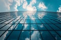 Bottom-up perspective view of modern office building with glass walls against the blue sky. The sky and light clouds are Royalty Free Stock Photo