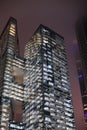 A bottom-up view of the facade of a modern office building at night in fog. Light of the night city. Moscow City Royalty Free Stock Photo