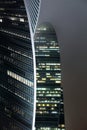 A bottom-up view of the facade of a modern office building at night in fog. Light of the night city. Moscow City Royalty Free Stock Photo