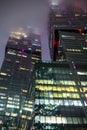 A bottom-up view of the facade of a modern office building at night in fog. Light of the night city. Moscow City Royalty Free Stock Photo