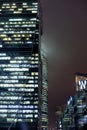 A bottom-up view of the facade of a modern office building at night in fog. Light of the night city. Moscow City Royalty Free Stock Photo