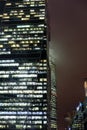 A bottom-up view of the facade of a modern office building at night in fog. Light of the night city. Moscow City Royalty Free Stock Photo