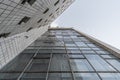 Bottom up view of the facade of an old Soviet modernist building lined with ceramic tiles with wide and small windows.