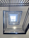 Bottom-up view of rectangular spiral staircase in modern multi-storey residential