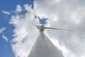 Bottom-up view of a wind turbine, sky with clouds as background Royalty Free Stock Photo