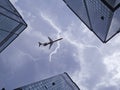 Bottom view of airplane flying above skyscraper Royalty Free Stock Photo