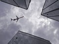 Bottom view of airplane flying above skyscraper Royalty Free Stock Photo