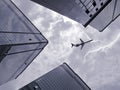 Bottom view of airplane flying above skyscraper Royalty Free Stock Photo