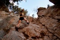 bottom view of athletic young woman who skilfully climbing up on rocks using rope. Royalty Free Stock Photo