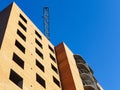 Bottom view of the brick multistory building with crane on the construction site under blue sky Royalty Free Stock Photo