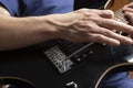 Bottom view and closeup to a male hands playing a black and yellow electric guitar at indoor Royalty Free Stock Photo