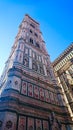 bottom view of the colourful decorated Bell Tower, Campanile di Giotto, from below under a bright blue clear sky