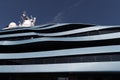 Bottom view of decks of huge yacht of blue color at sunny day, glossy board of the motor boat, sun reflection on glossy