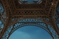 Bottom view of Eiffel Tower made in iron and Art Nouveau style, with sunny blue sky in Paris. Royalty Free Stock Photo