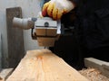 Bottom view of an electric planer in the hands of a carpenter