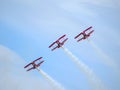 Bottom view of flying three red aircraft performing stunts during an airshow