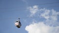 Bottom view of the funicular cable railway, cabins moving on blue cloudy sky background. Action. New cabins moving