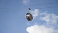 Bottom view of the funicular cable railway, cabins moving on blue cloudy sky background. Action. New cabins moving