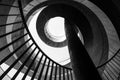 Bottom view of a geometric abstraction in the form of a spirally twisted metal staircase with a railing. Black and white photo Royalty Free Stock Photo