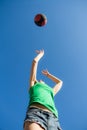 Bottom view of a girl in a jump throws a basketball over the blue sky, sports concept Royalty Free Stock Photo