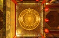 Bottom view of golden chandelier hanging ceiling golden light with red lamp lanterns in Chinese temple. Circle square frame.