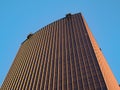 Bottom view of golden skyscraper against blue sky. Royalty Free Stock Photo