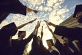 Bottom view graduates lift their diplomas and stack them together against a blue sky with clouds. Royalty Free Stock Photo