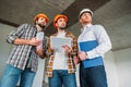 bottom view of group of architects with tablet looking away inside of