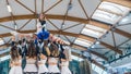 Bottom view of a group of cheerleaders in uniforms posing in a gymnastic figure. Cheerleader on top is holding blue pom