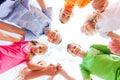 Bottom view of group of happy schoolchildren standing in circle