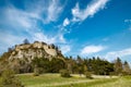 Bottom view of a hill with the ruins of the Hohentwil castle on its top against a blue sky Royalty Free Stock Photo