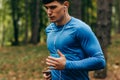 Bottom view image of young athelte man running outdoor in the morning in the forest background. Royalty Free Stock Photo